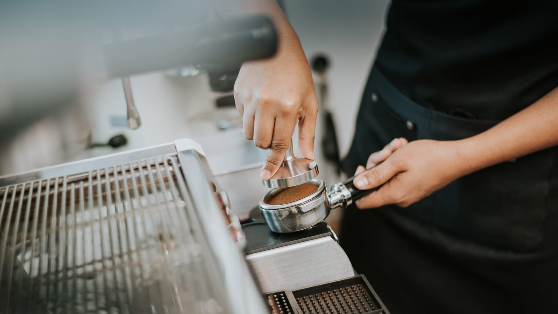 Barista tamping coffee during a course